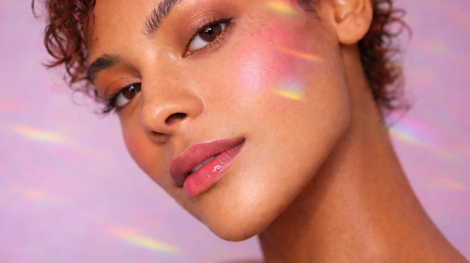 Close-up of a model wearing softly sculpted bronzer with warm, sun-kissed skin and natural glow across the cheeks and eyes