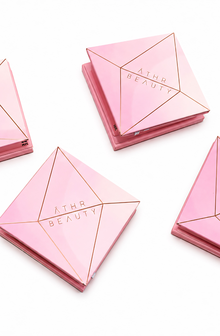 Four pink cosmetic cases with 'Athr Beauty' branding on a white background