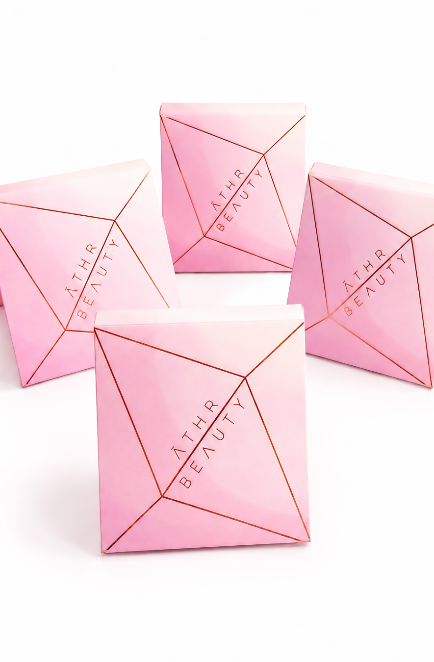 Four pink pyramid-shaped containers with 'Athr Beauty' branding on a white background