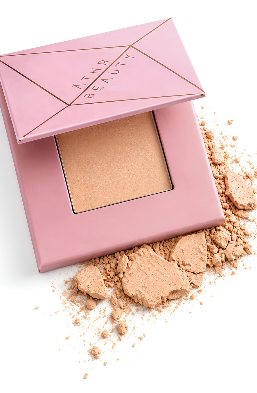 Open pink compact powder of Athr Beauty's 'Desert Mirage Blurring Powder' in the shade 'Citrine Sand' (a soft, warm beige with a banana-yellow tint) on a white background
