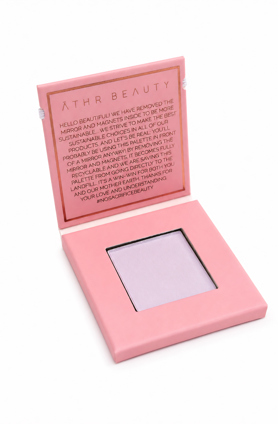 Pink makeup compact with lavender powder on a white background