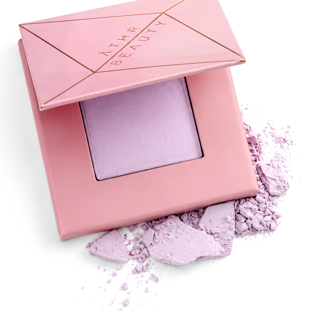 Pink makeup compact with lavender powder on a white background