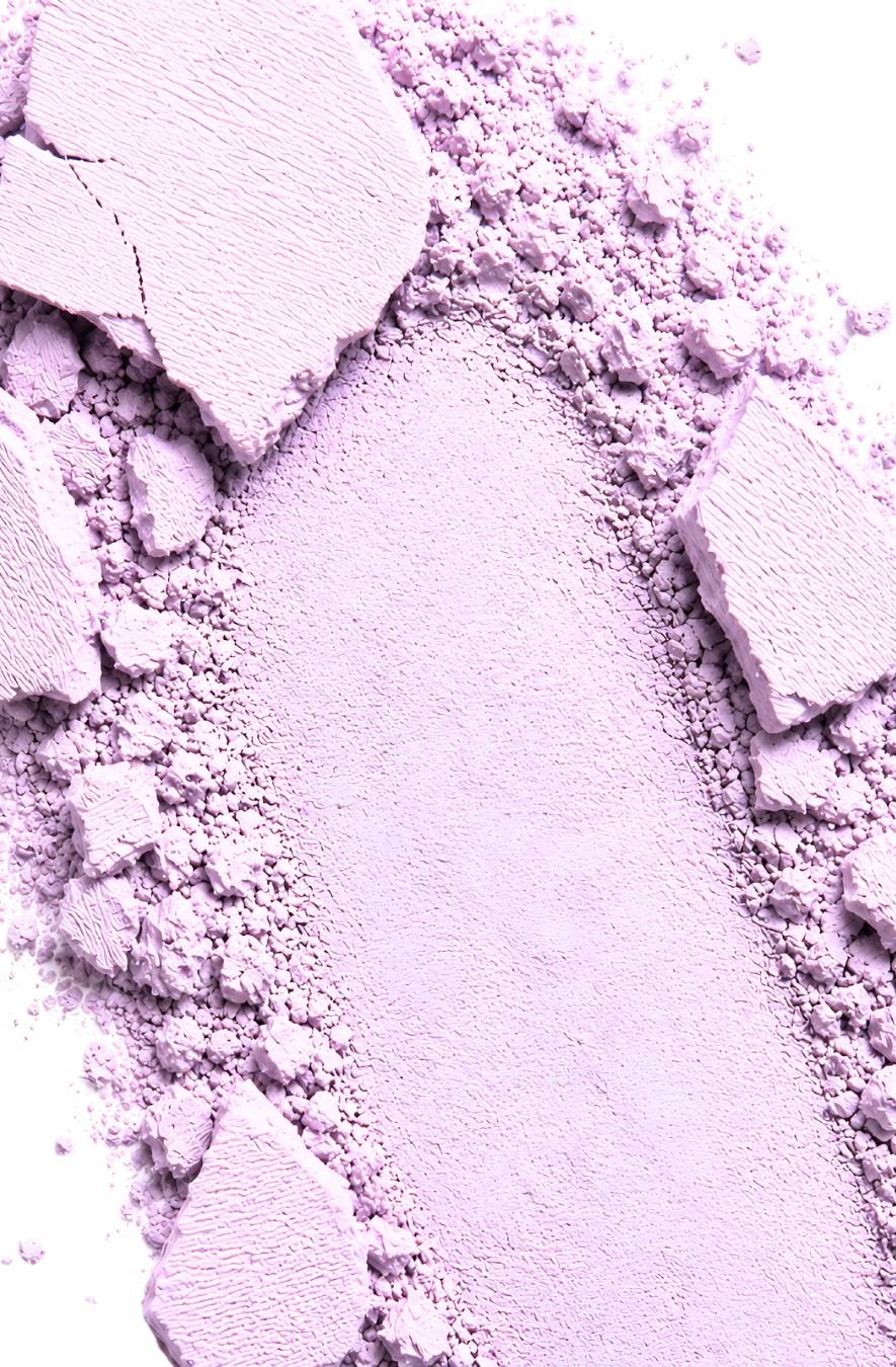 Close-up of lavender makeup powder with chunks on a white background