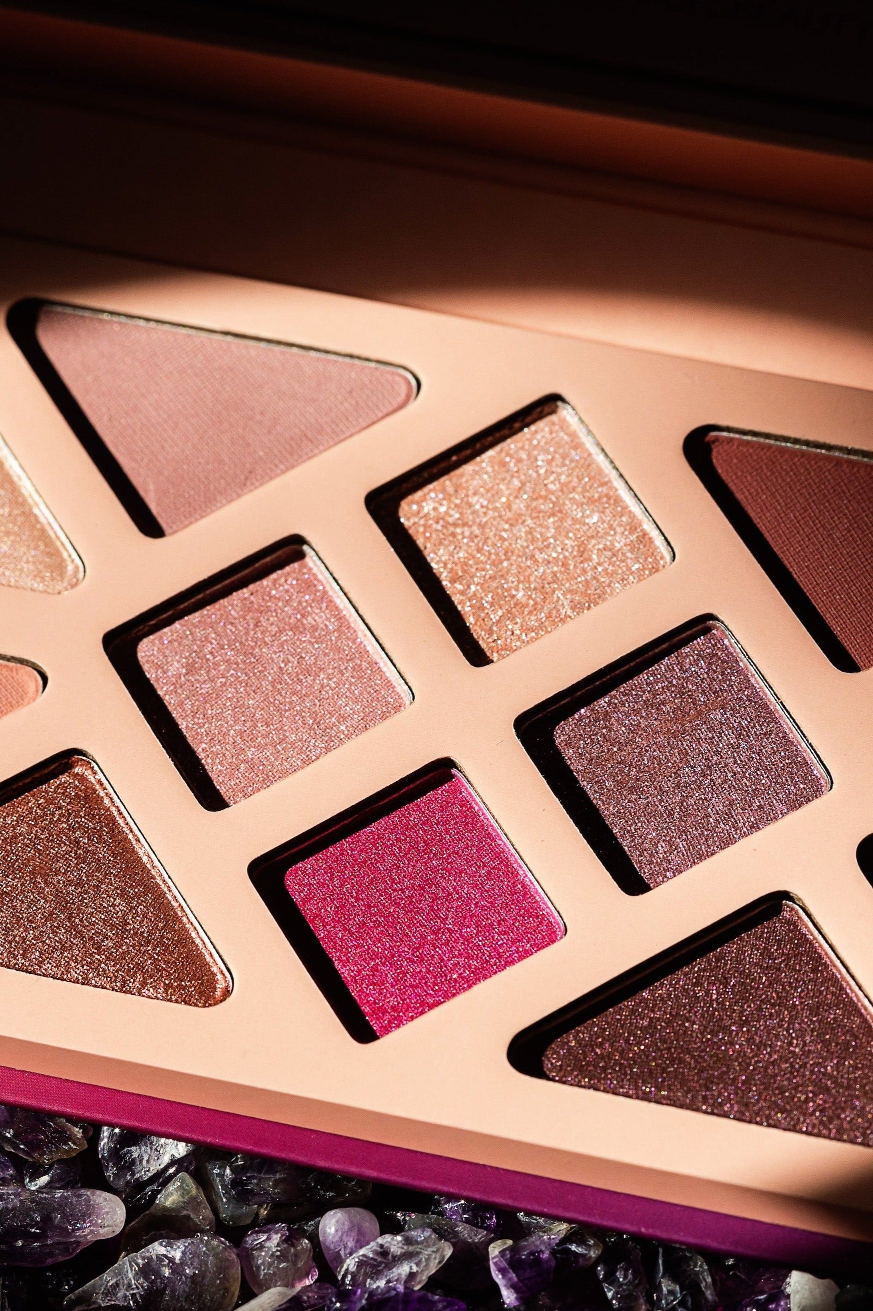 Editorial product image of the 12-Pan "Manifest" Crystal Eyeshadow Palette, sitting open to show the shade color.