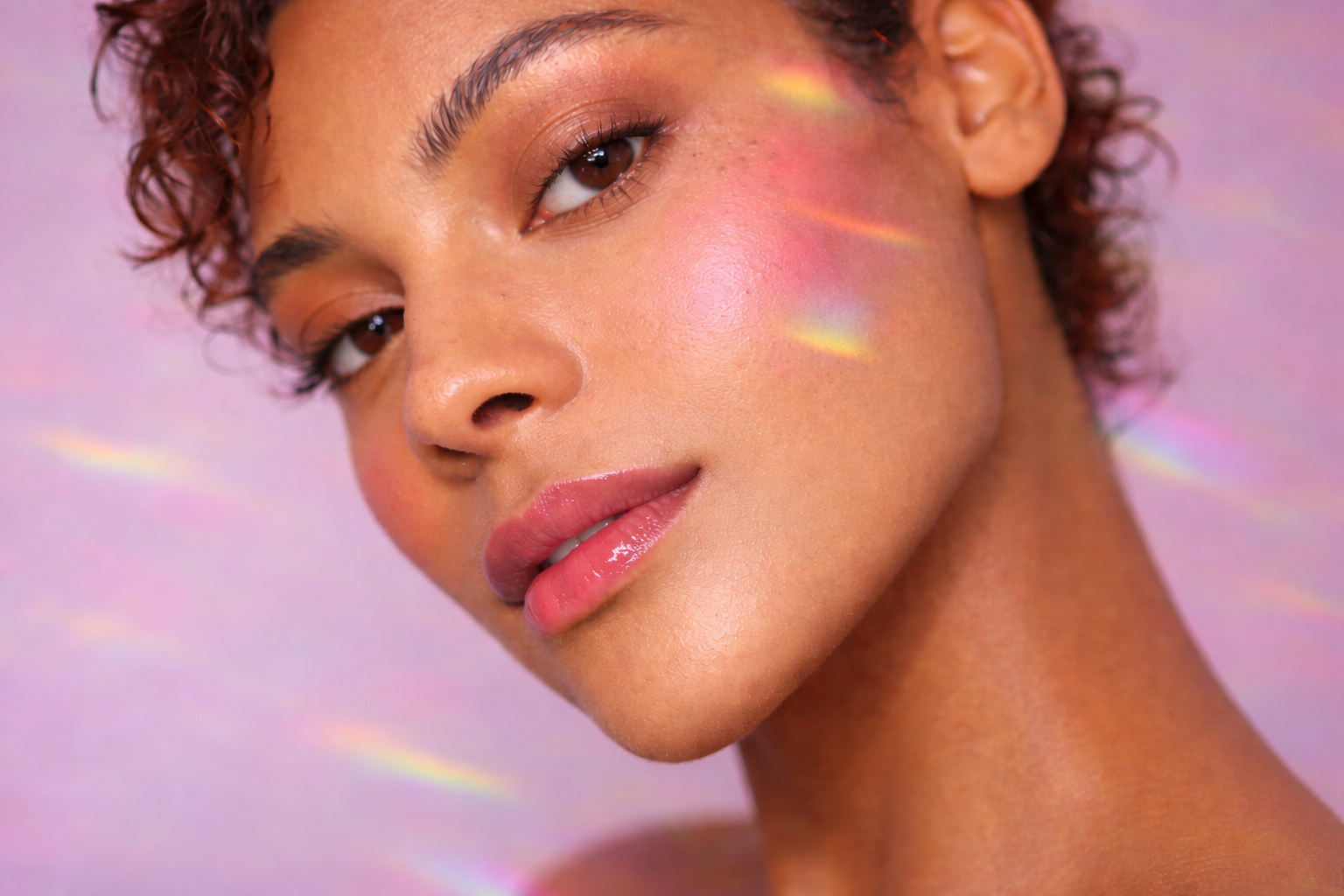 Close-up of a model wearing softly sculpted bronzer with warm, sun-kissed skin and natural glow across the cheeks and eyes
