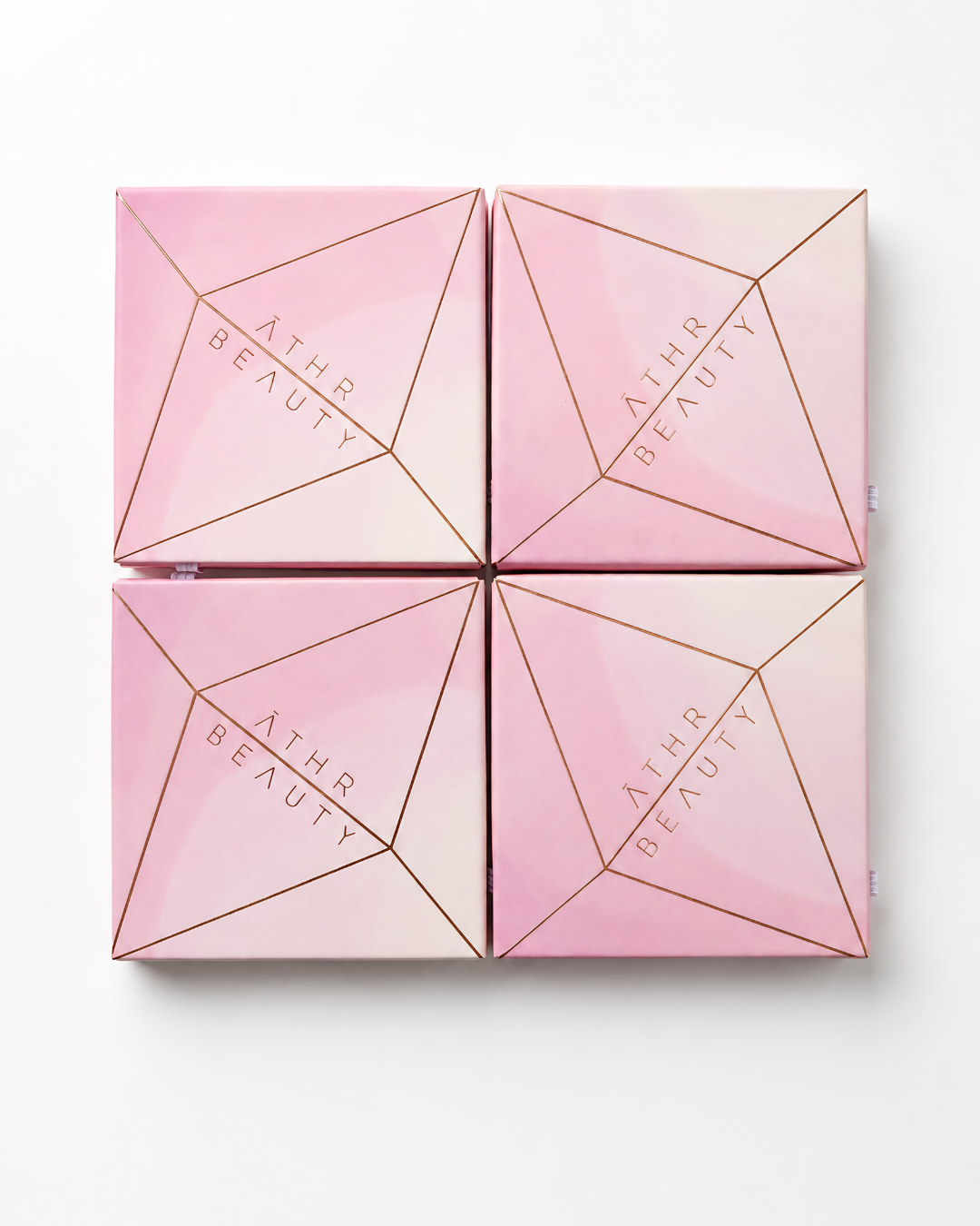 Pink cosmetic box with geometric design and 'Athr Beauty' branding on a white background