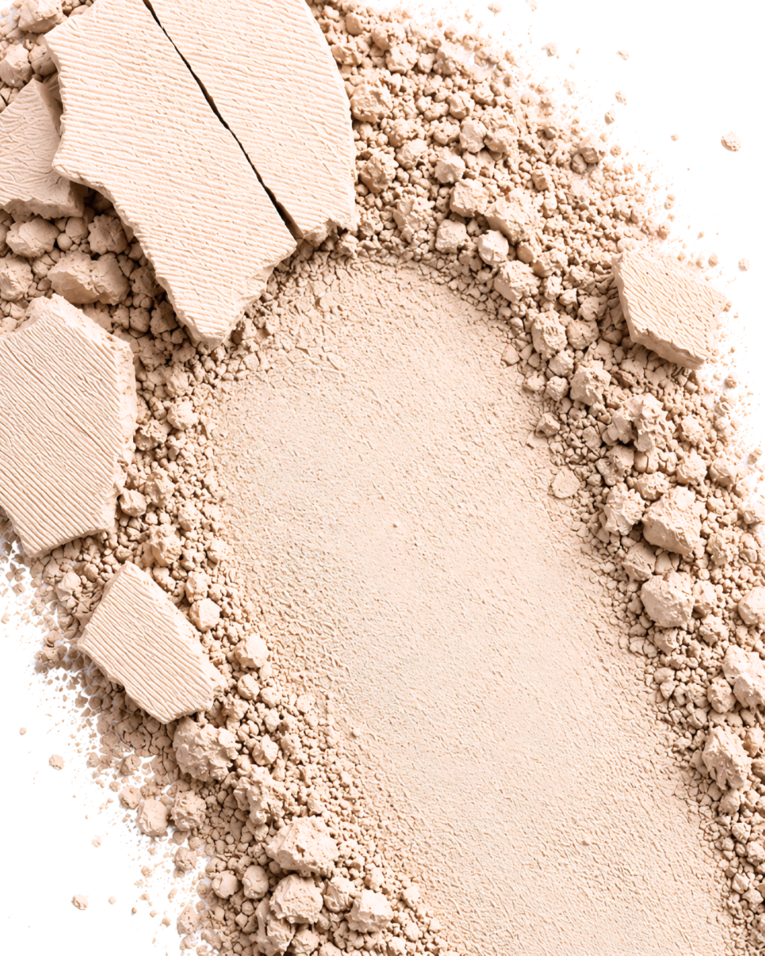 Close-up of Athr Beauty's 'Desert Mirage Blurring Powder' in the shade 'Rose Mesa' (a soft, creamy beige with a subtle pink tint) makeup powder with a few chunks on a white background