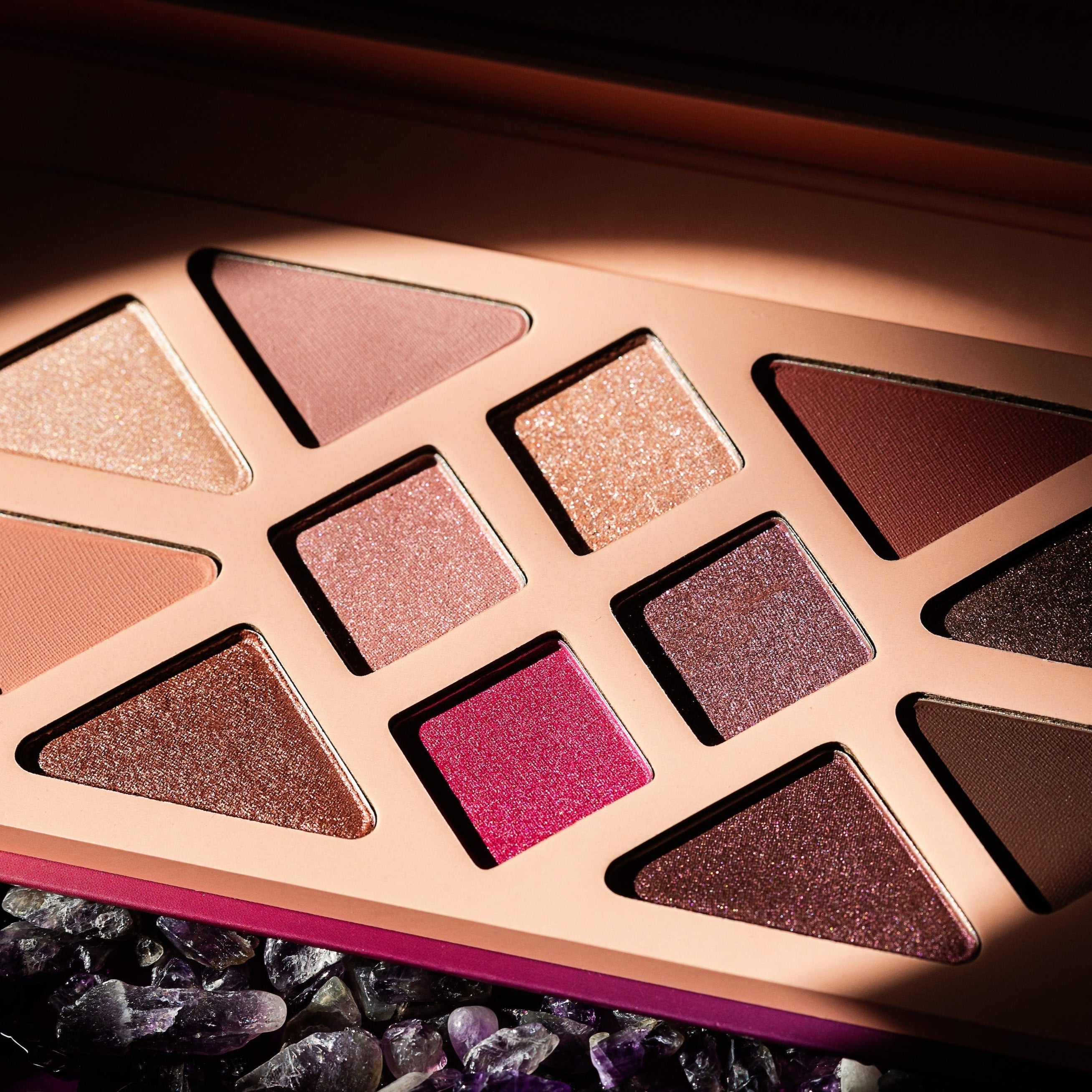 Editorial product image of the 12-Pan "Manifest" Crystal Eyeshadow Palette, sitting open to show the shade color.